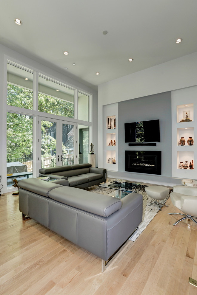 На фото: открытая гостиная комната среднего размера в современном стиле с серыми стенами, светлым паркетным полом, стандартным камином, фасадом камина из плитки и телевизором на стене