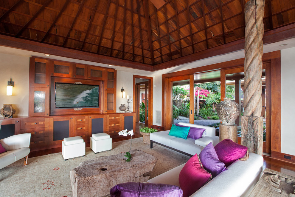 Foto de sala de estar cerrada exótica de tamaño medio sin chimenea con paredes blancas, suelo de madera en tonos medios y pared multimedia