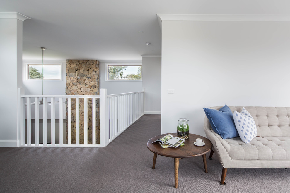Modelo de sala de estar abierta de estilo de casa de campo de tamaño medio con paredes blancas, moqueta, todas las chimeneas, marco de chimenea de piedra y suelo gris