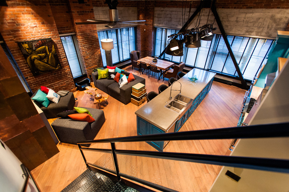 Offenes Industrial Wohnzimmer mit hellem Holzboden und bunten Wänden in Vancouver