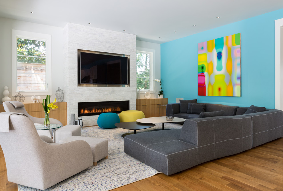 Idées déco pour une salle de séjour contemporaine avec un mur bleu, un sol en bois brun, une cheminée ribbon et un téléviseur fixé au mur.