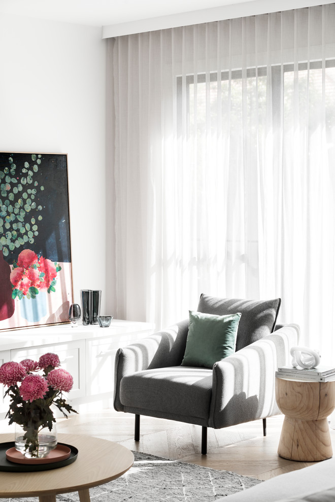 Modelo de sala de estar abierta contemporánea con paredes blancas, suelo de madera en tonos medios, todas las chimeneas, marco de chimenea de ladrillo, televisor colgado en la pared y suelo marrón
