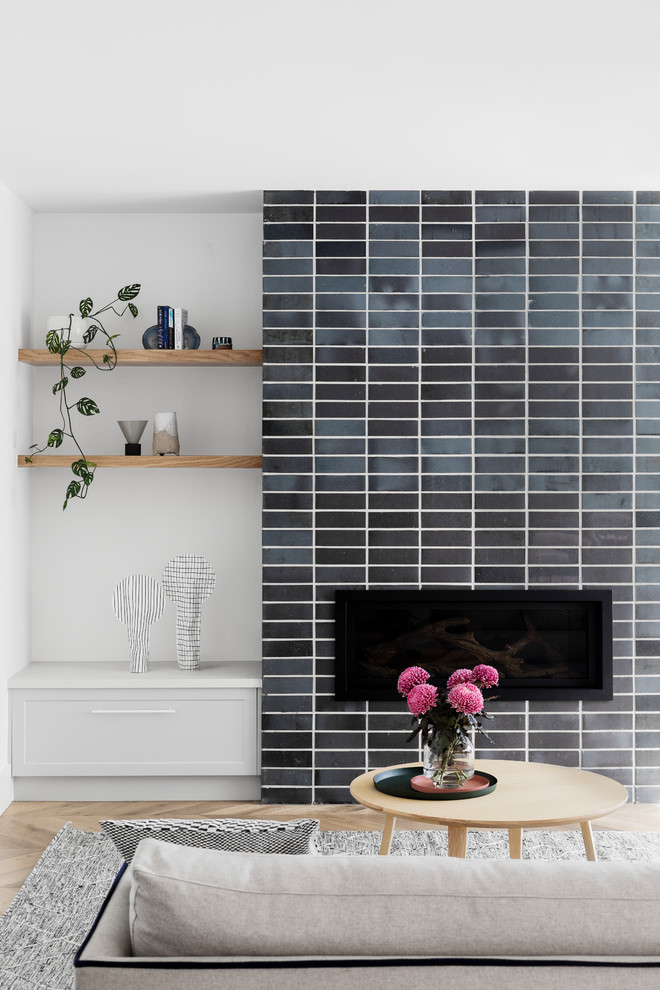 Inspiration for a contemporary open concept medium tone wood floor and brown floor family room remodel in Melbourne with white walls, a standard fireplace, a brick fireplace and a wall-mounted tv