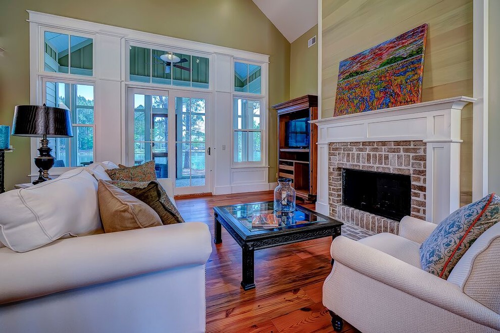 Large transitional open concept medium tone wood floor family room photo in Atlanta with beige walls, a standard fireplace, a brick fireplace and a tv stand