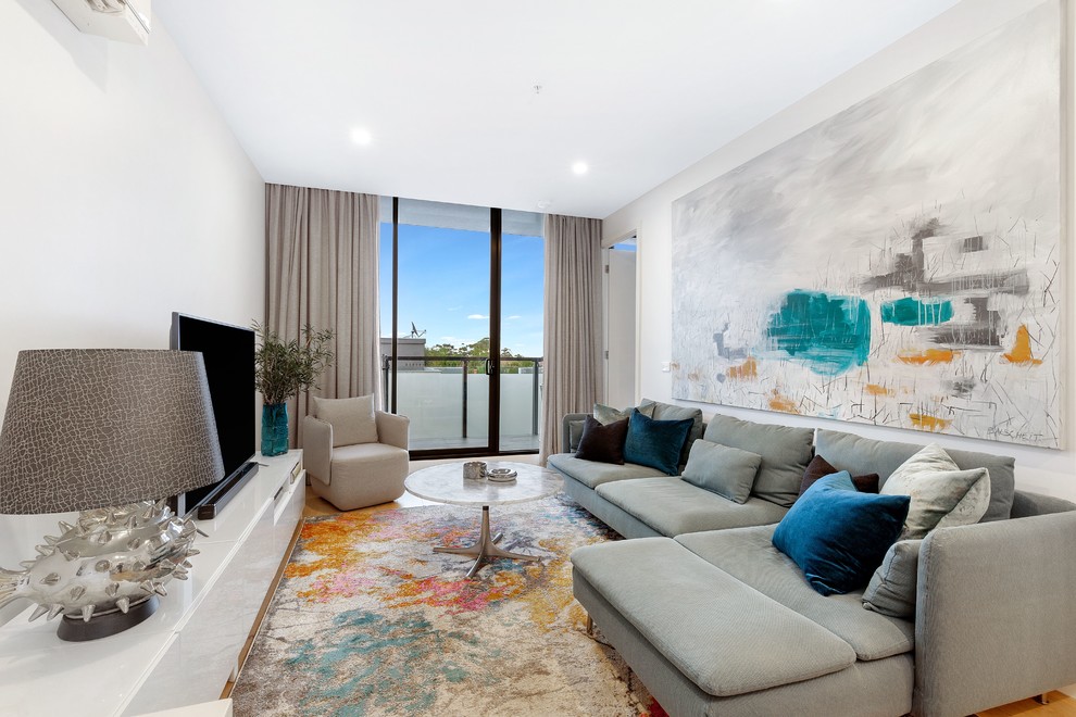 Inspiration pour une salle de séjour design avec un mur blanc, un sol en bois brun, un téléviseur indépendant et un sol marron.
