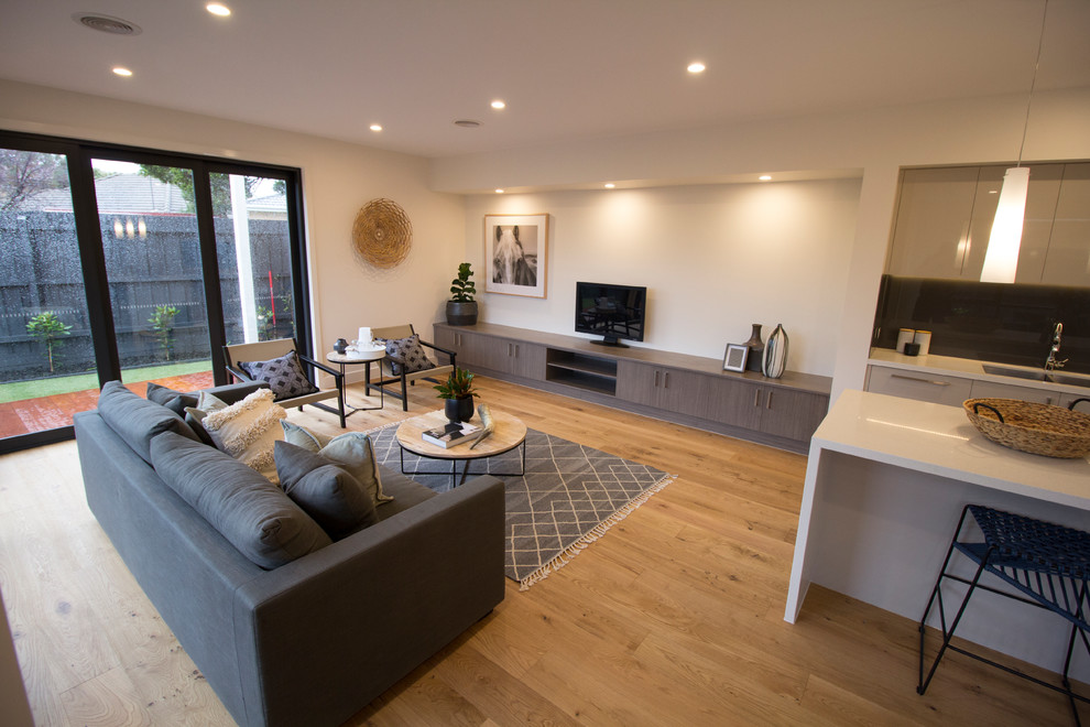 Diseño de sala de estar abierta contemporánea grande con paredes blancas y suelo de madera clara