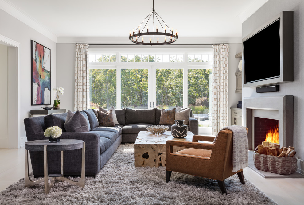 Foto di un soggiorno stile marinaro con pareti grigie, parquet chiaro, camino classico, TV a parete e tappeto
