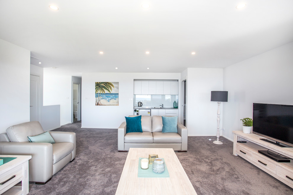 Imagen de sala de estar abierta marinera de tamaño medio sin chimenea con paredes blancas, moqueta, televisor independiente y suelo gris