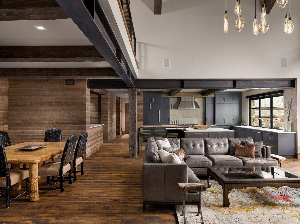 Design ideas for a large rustic open plan games room in Denver with dark hardwood flooring, a standard fireplace, a stone fireplace surround and a wall mounted tv.