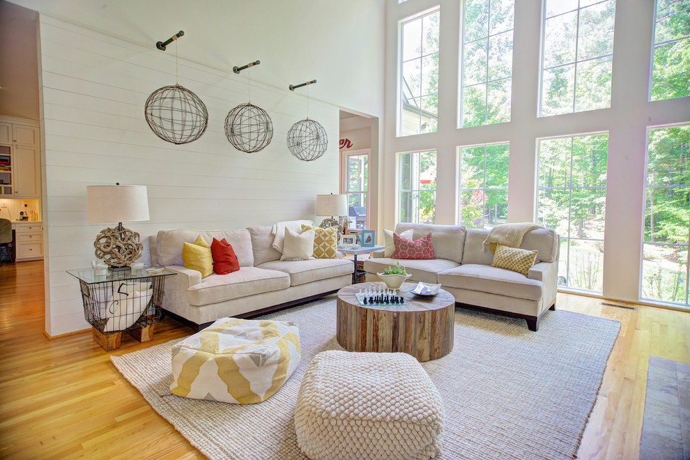 Immagine di un soggiorno chic aperto con pareti bianche, pavimento in legno massello medio e pavimento marrone