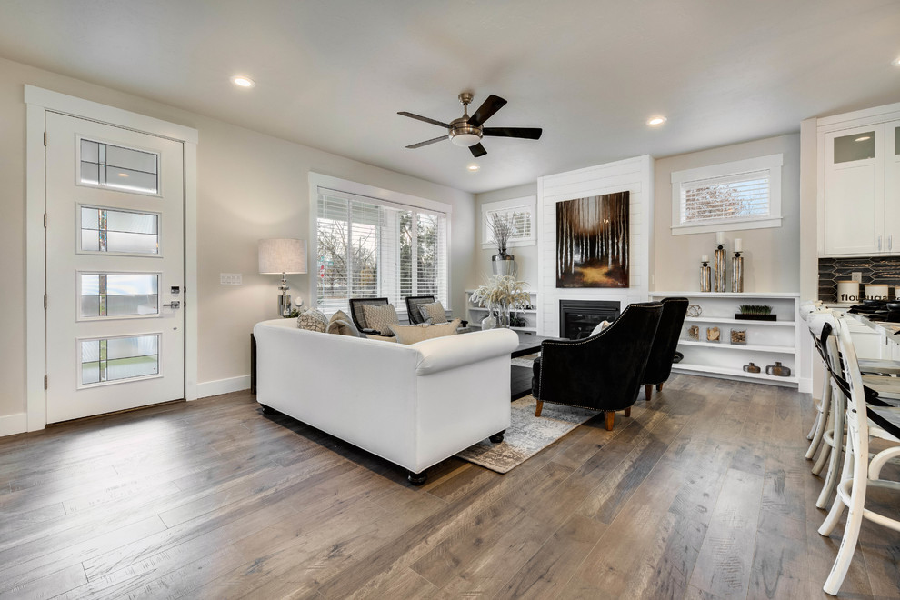 Mittelgroßes, Offenes Country Wohnzimmer mit weißer Wandfarbe, braunem Holzboden, Kamin und Kaminumrandung aus Holz in Boise