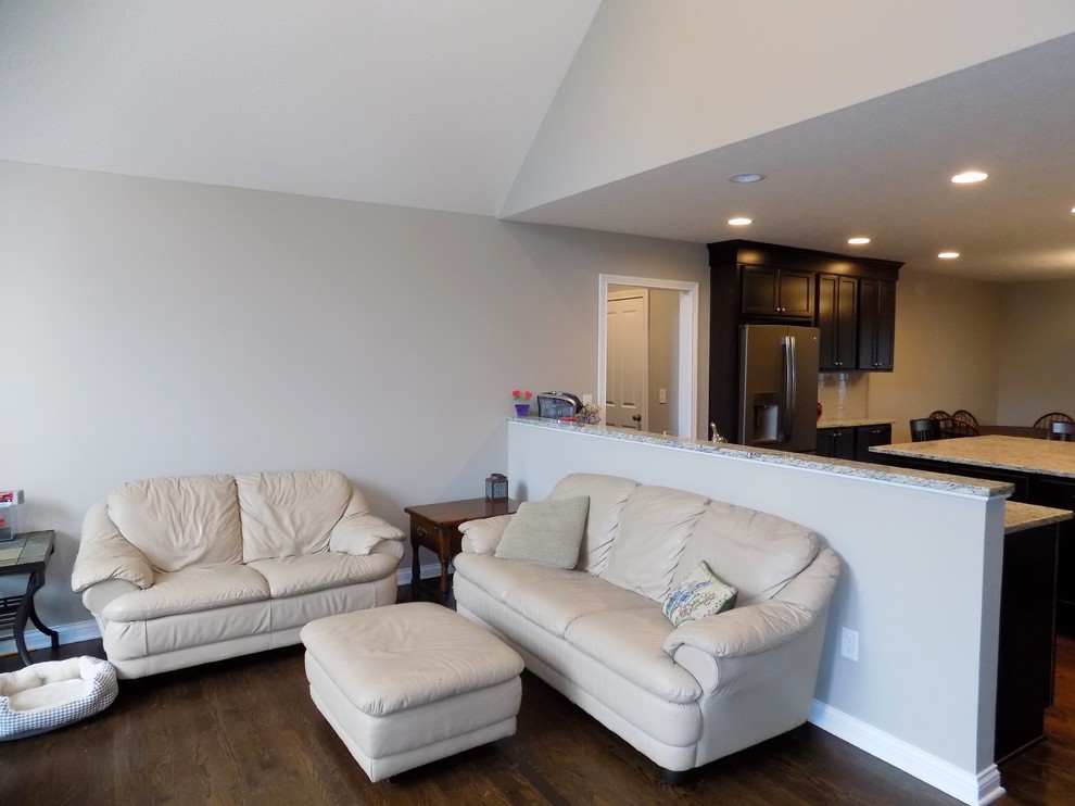 Diseño de sala de estar abierta actual de tamaño medio con paredes grises, suelo de madera en tonos medios y televisor independiente