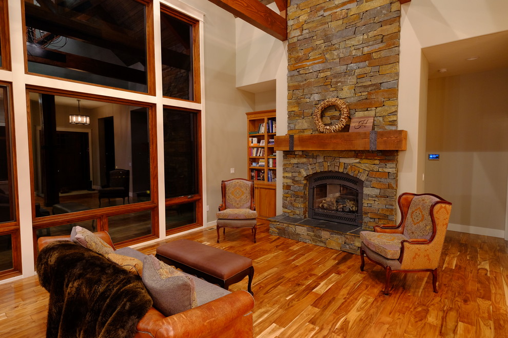 サクラメントにある高級な広いトラディショナルスタイルのおしゃれなオープンリビング (無垢フローリング、標準型暖炉、石材の暖炉まわり、ベージュの壁、テレビなし、茶色い床) の写真