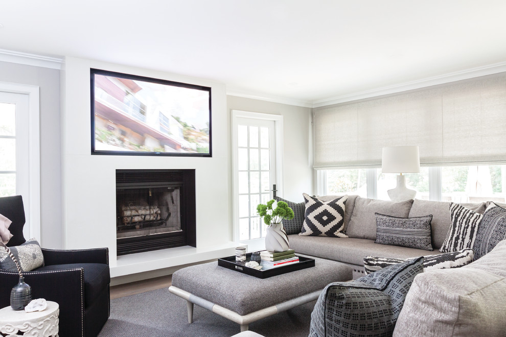 Klassisches Wohnzimmer mit Kamin, Multimediawand, weißer Wandfarbe, hellem Holzboden und braunem Boden in New York