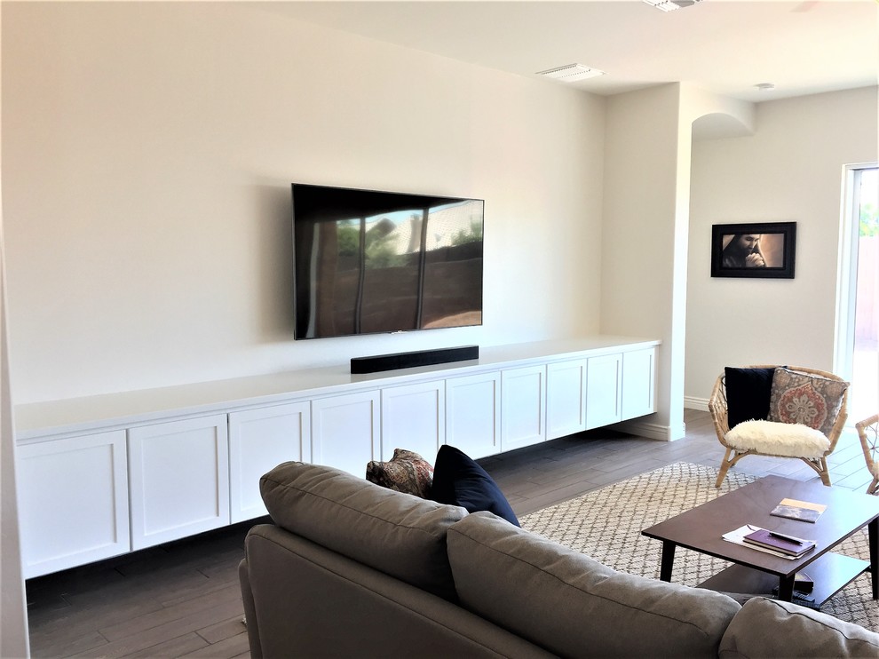 Идея дизайна: большая открытая комната для игр в стиле неоклассика (современная классика) с белыми стенами, полом из керамической плитки, телевизором на стене и бежевым полом без камина
