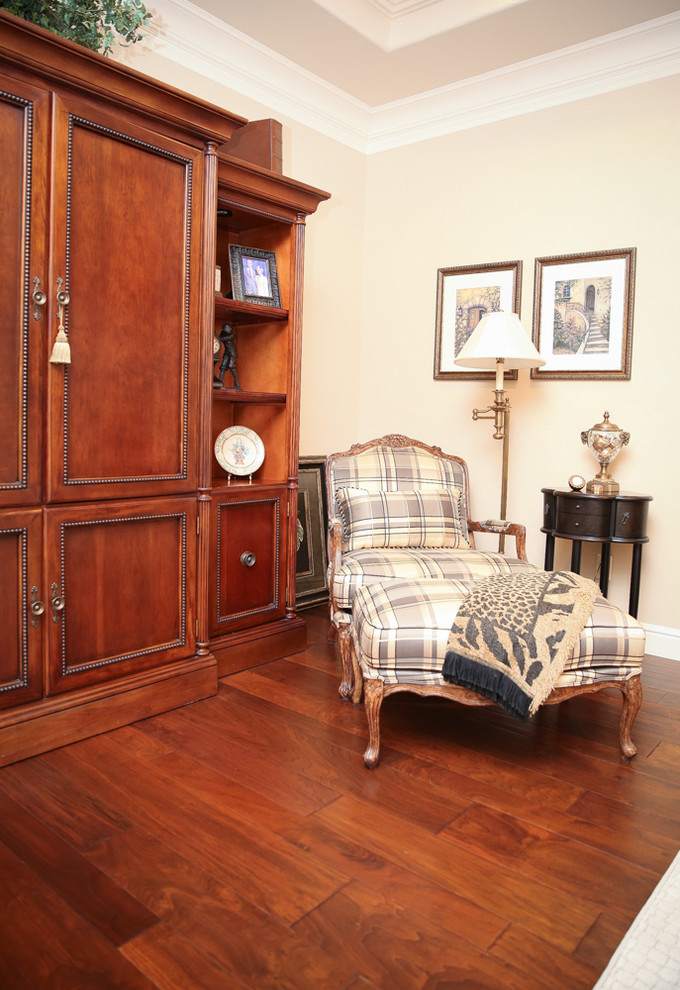 Imagen de sala de estar abierta contemporánea de tamaño medio sin chimenea con suelo marrón, paredes beige, suelo de madera en tonos medios y televisor retractable