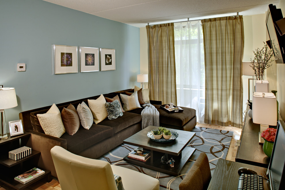 Cette photo montre une salle de séjour chic de taille moyenne et fermée avec un mur bleu, parquet clair, un téléviseur fixé au mur, aucune cheminée et un sol bleu.