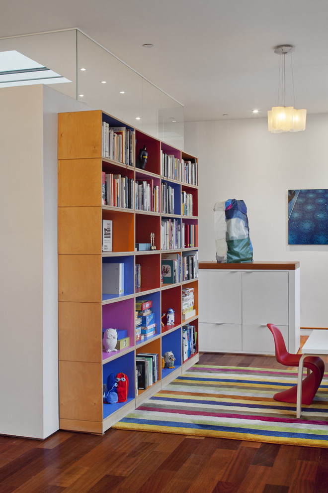 Diseño de sala de estar con biblioteca contemporánea con paredes blancas y suelo de madera en tonos medios