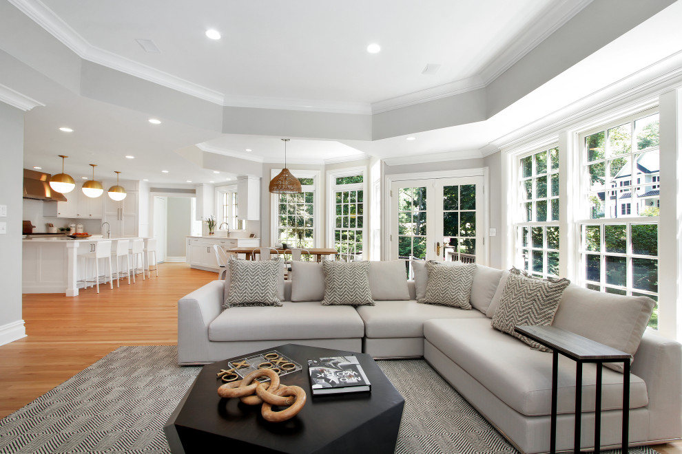 Ejemplo de sala de estar abierta tradicional renovada de tamaño medio con paredes blancas, suelo de madera en tonos medios, televisor colgado en la pared y suelo beige