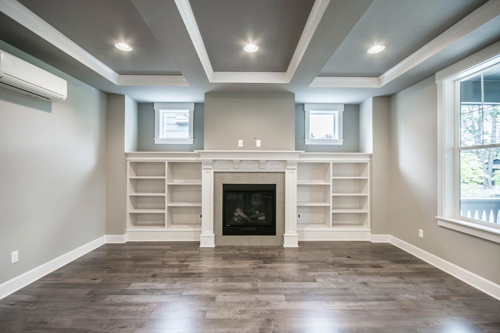 Inspiration for a traditional games room in Portland with grey walls, medium hardwood flooring, a standard fireplace and a tiled fireplace surround.