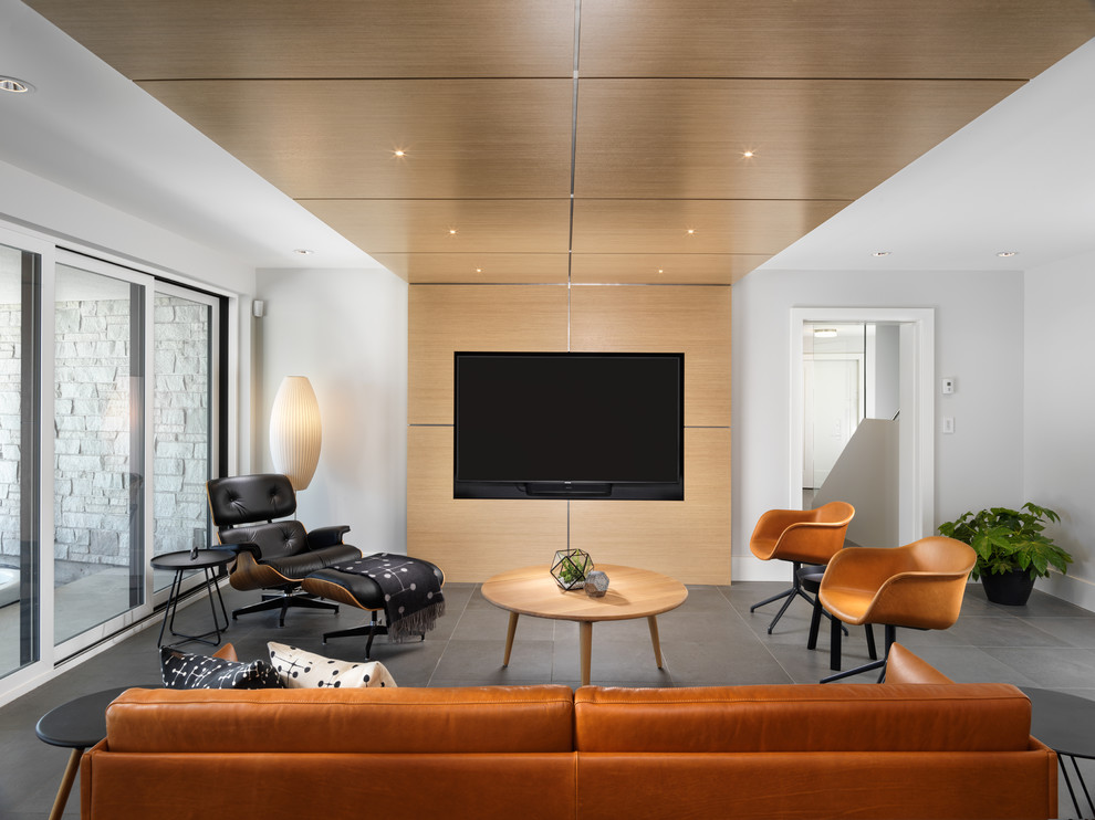 Modelo de sala de estar contemporánea sin chimenea con paredes grises, pared multimedia y suelo gris