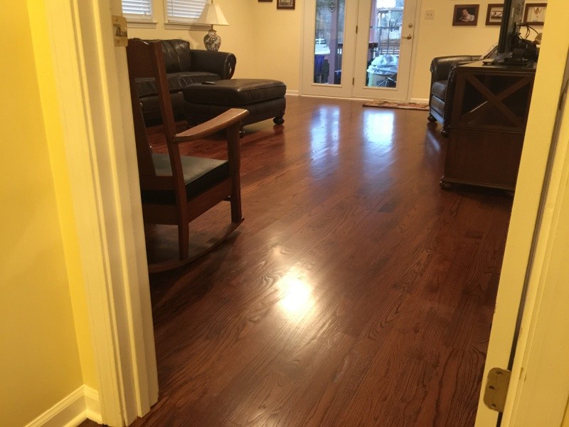 Elegant medium tone wood floor family room photo in Other