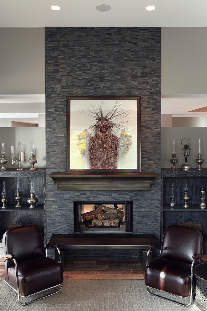 Example of a large trendy medium tone wood floor family room design in Grand Rapids with gray walls, a standard fireplace and a stone fireplace