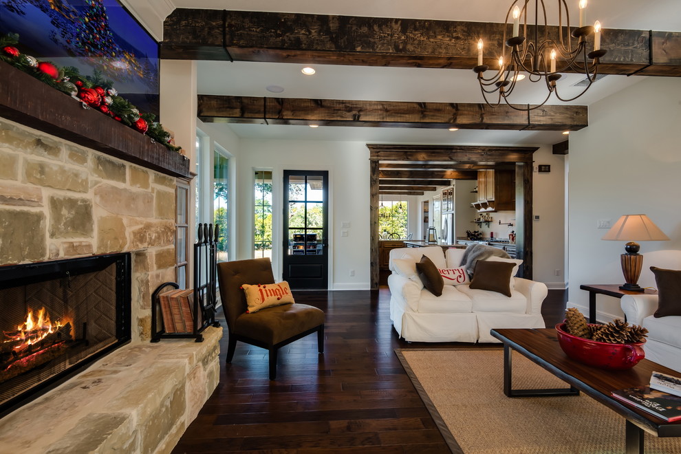 Large classic open plan games room in Austin with white walls, dark hardwood flooring, a standard fireplace, a stone fireplace surround and a wall mounted tv.