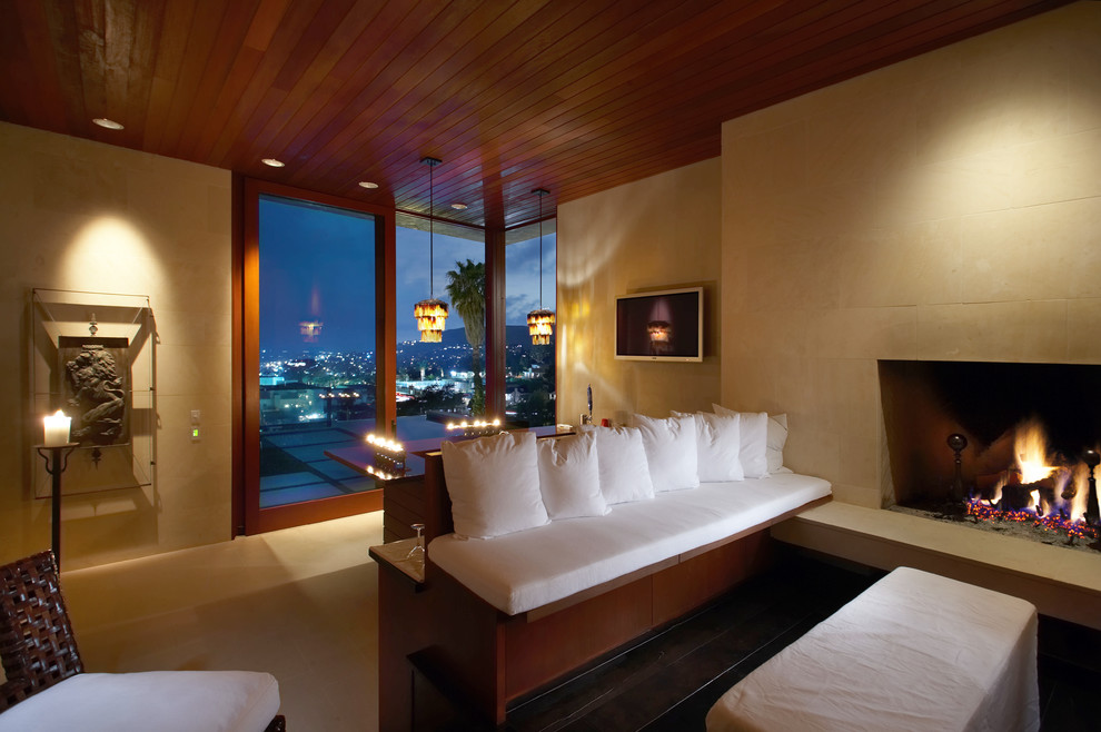 Свежая идея для дизайна: гостиная комната в современном стиле с бежевыми стенами, стандартным камином и телевизором на стене - отличное фото интерьера
