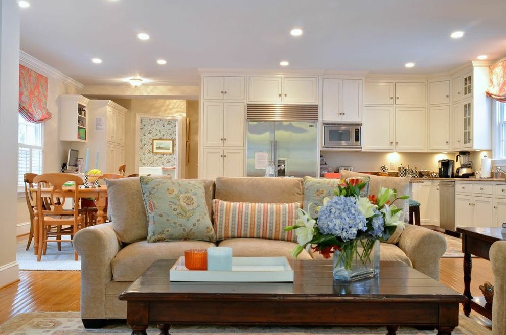Immagine di un soggiorno chic di medie dimensioni e aperto con pareti beige, parquet chiaro, nessun camino e TV a parete