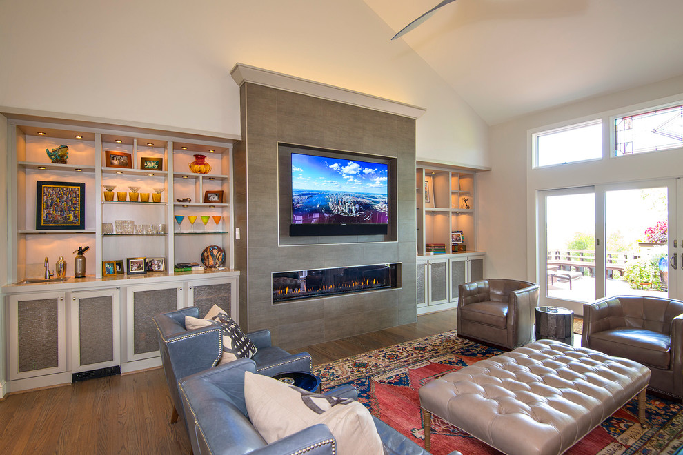 Идея дизайна: большая изолированная гостиная комната в стиле неоклассика (современная классика) с домашним баром, белыми стенами, паркетным полом среднего тона, горизонтальным камином, фасадом камина из плитки, телевизором на стене и коричневым полом