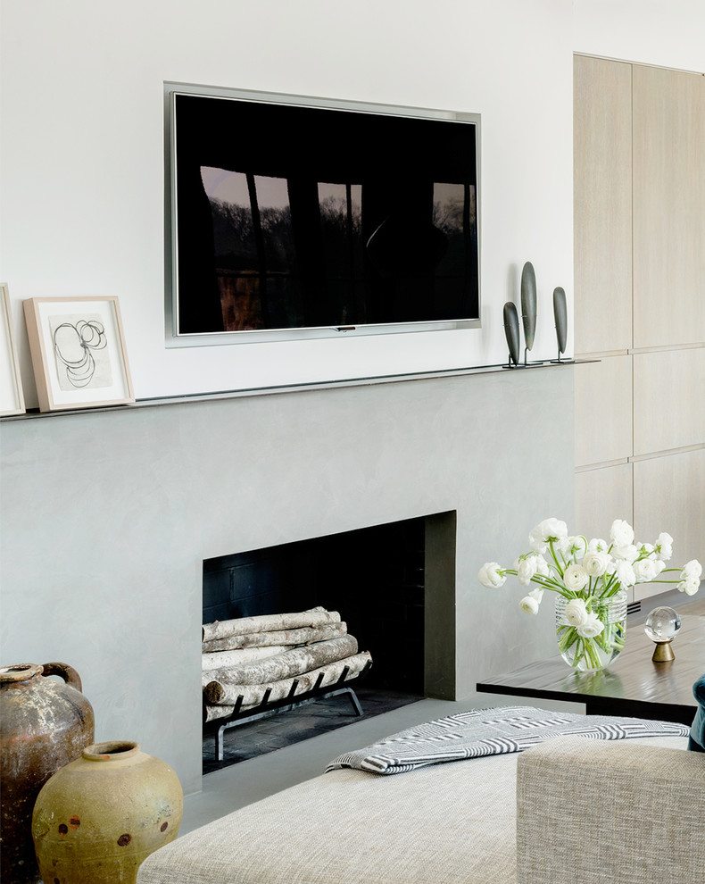 Exempel på ett mellanstort modernt allrum med öppen planlösning, med vita väggar, kalkstensgolv, en standard öppen spis, en spiselkrans i betong, en väggmonterad TV och grått golv