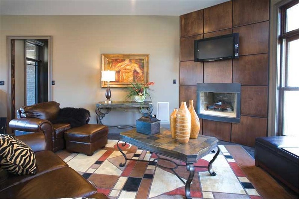 Immagine di un soggiorno design di medie dimensioni e chiuso con pareti beige, pavimento in ardesia, camino classico, cornice del camino in legno e TV a parete