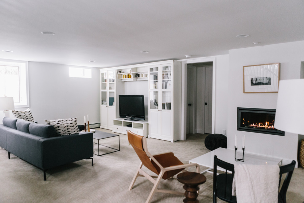 Стильный дизайн: большая изолированная гостиная комната в стиле модернизм с белыми стенами, горизонтальным камином, ковровым покрытием, фасадом камина из металла, отдельно стоящим телевизором и бежевым полом - последний тренд