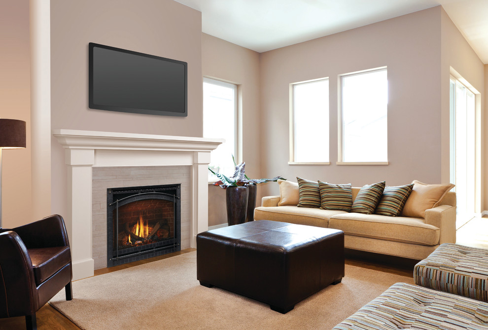 Inspiration for a medium sized contemporary open plan games room in Providence with grey walls, medium hardwood flooring, a standard fireplace, a tiled fireplace surround, a wall mounted tv and brown floors.