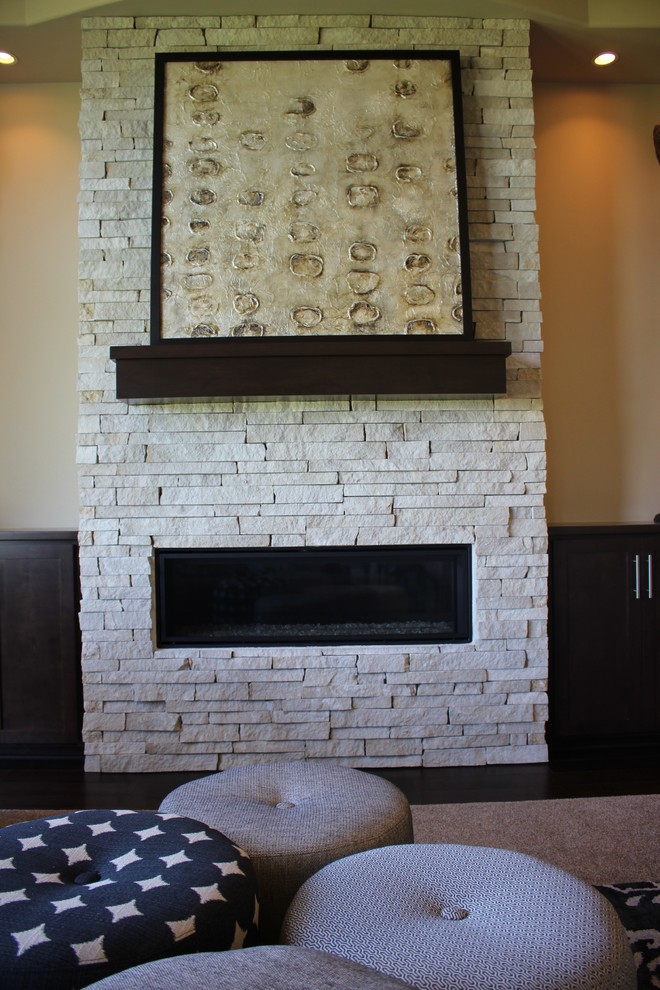 Fernseherloses, Offenes Modernes Wohnzimmer mit Kaminumrandung aus Stein, beiger Wandfarbe und Gaskamin in Minneapolis