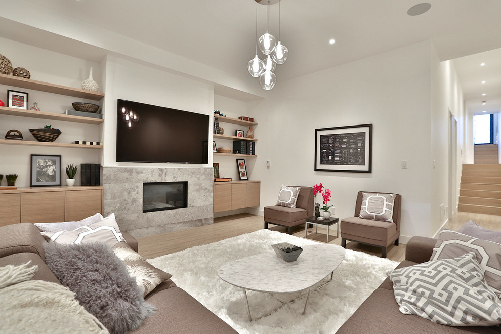Mid-sized trendy enclosed light wood floor family room photo in Toronto with white walls, a standard fireplace, a tile fireplace and a wall-mounted tv