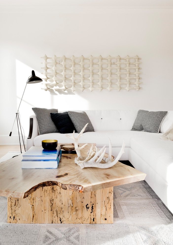 Foto på ett stort minimalistiskt avskilt allrum, med vita väggar, ljust trägolv, en standard öppen spis, en spiselkrans i sten och beiget golv