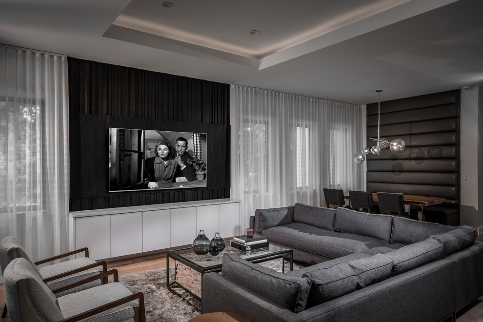Foto di un soggiorno design aperto con pavimento in legno massello medio, TV a parete e pavimento marrone