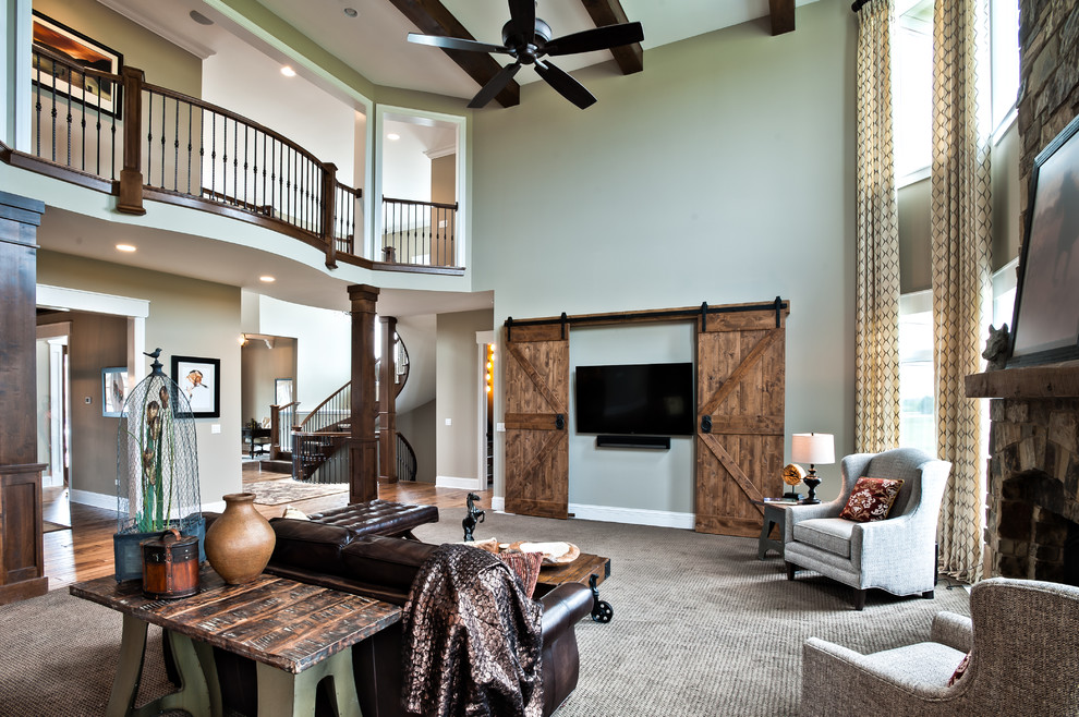 Large mountain style open concept carpeted and beige floor family room photo in Chicago with a standard fireplace, a stone fireplace, a wall-mounted tv and green walls