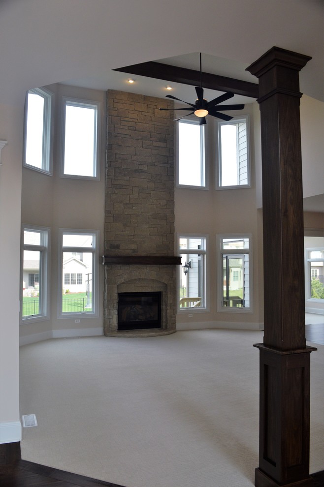 Ejemplo de sala de estar abierta clásica renovada con moqueta y marco de chimenea de piedra