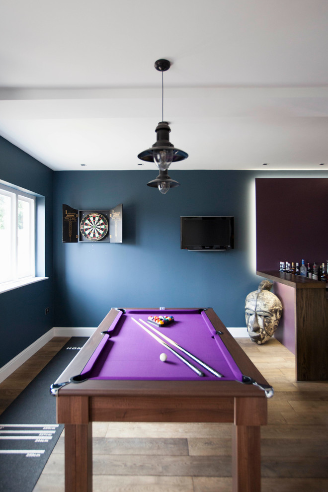 Contemporary games room in Oxfordshire with medium hardwood flooring.