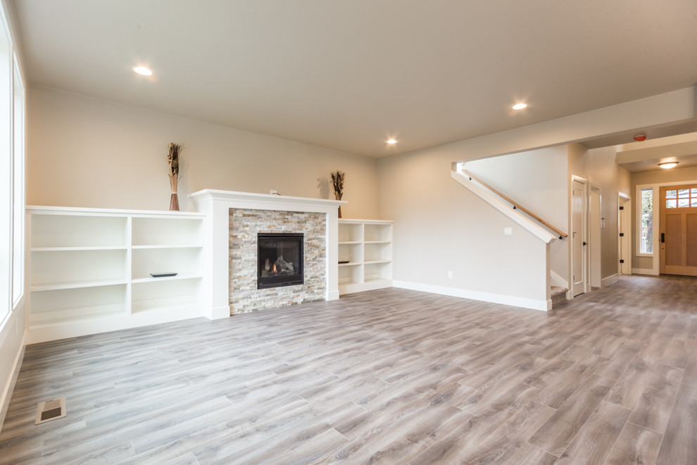 Mid-sized elegant open concept laminate floor and brown floor family room photo in Portland with beige walls, a standard fireplace and a stone fireplace