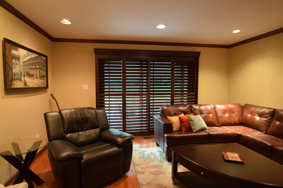 Idee per un soggiorno chic di medie dimensioni e chiuso con pareti gialle e pavimento in legno massello medio