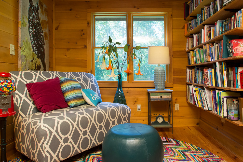 Diseño de sala de estar con biblioteca rústica con paredes marrones, suelo de madera en tonos medios y suelo marrón