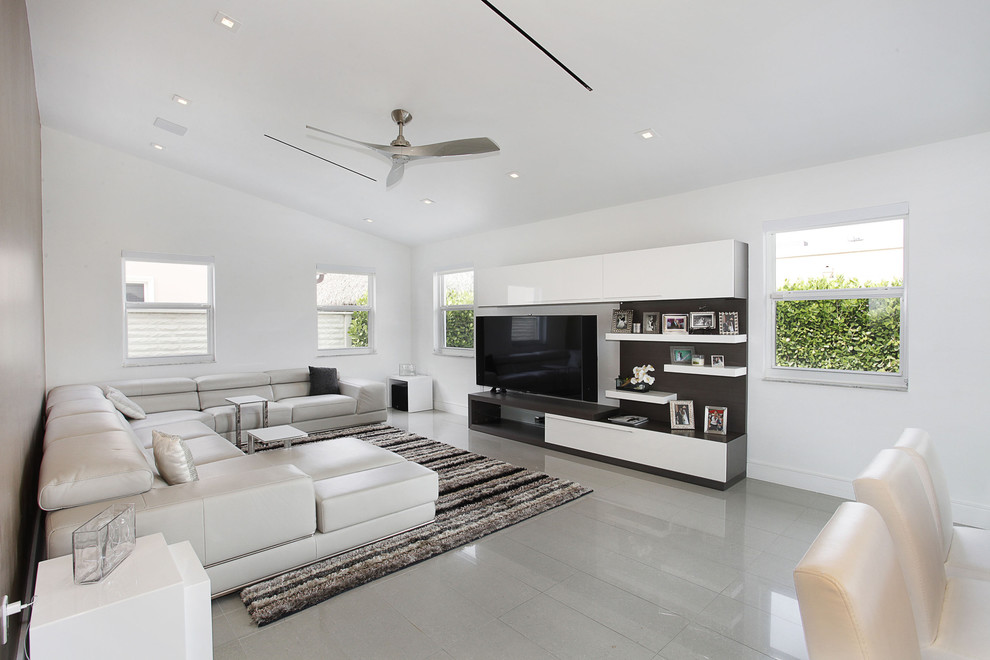 Ejemplo de sala de estar abierta contemporánea de tamaño medio sin chimenea con paredes blancas, suelo de linóleo y televisor independiente