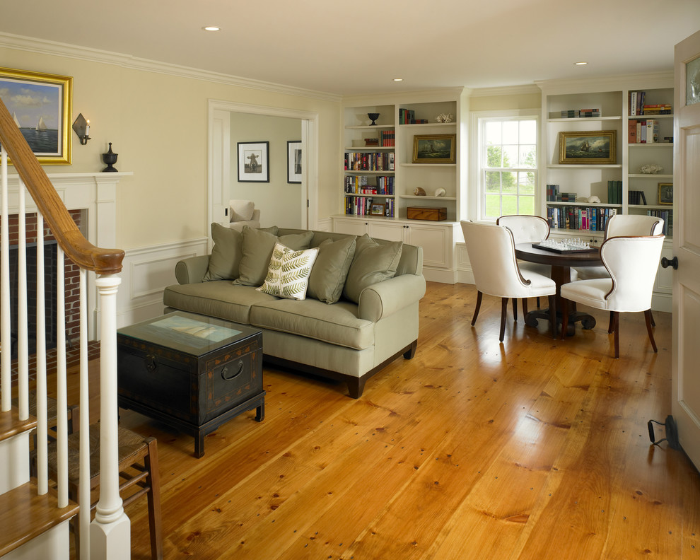 Mittelgroßes, Abgetrenntes Landhaus Wohnzimmer mit beiger Wandfarbe, braunem Holzboden, Kamin, Kaminumrandung aus Backstein und orangem Boden in Boston