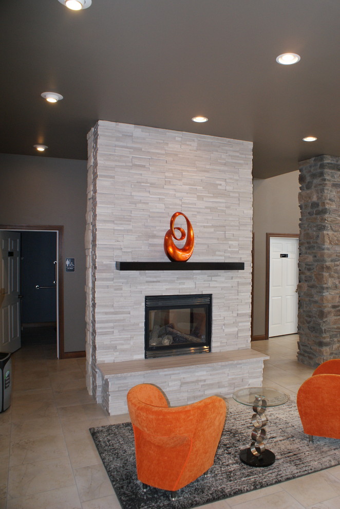 Modelo de sala de estar abierta urbana de tamaño medio sin televisor con suelo de baldosas de cerámica, chimenea de doble cara y marco de chimenea de piedra