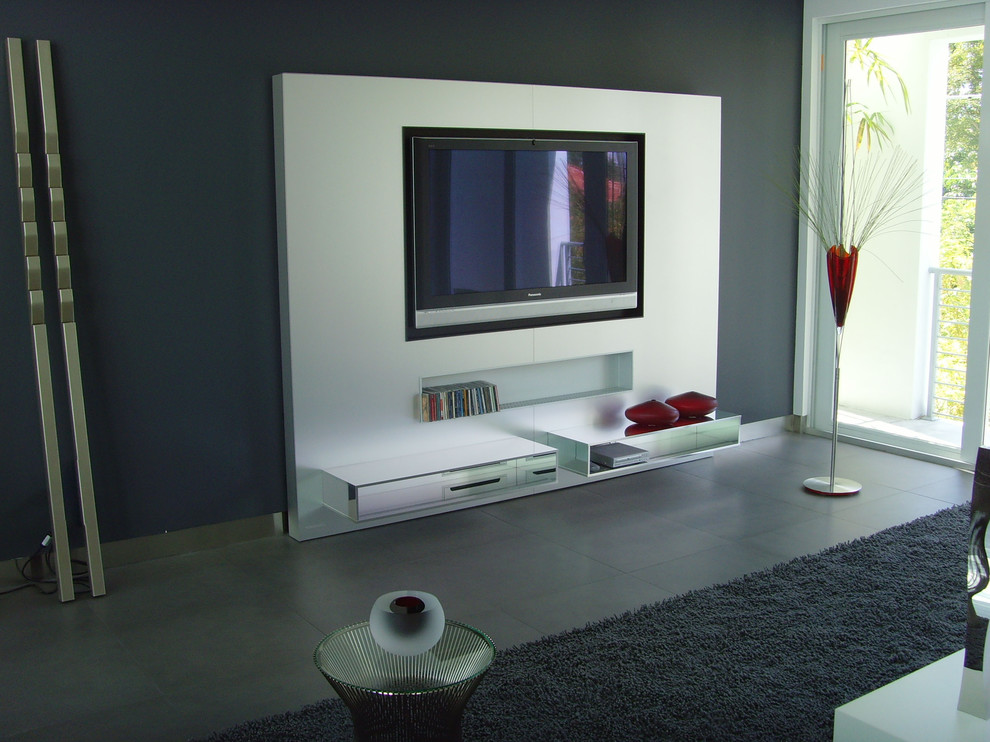 Example of a mid-sized trendy open concept slate floor and gray floor family room design in Miami with gray walls, no fireplace and a media wall