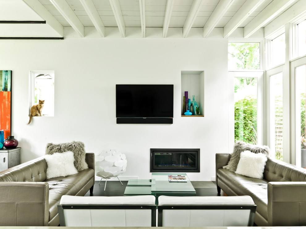 Inspiration pour une salle de séjour design avec un mur blanc et un téléviseur fixé au mur.